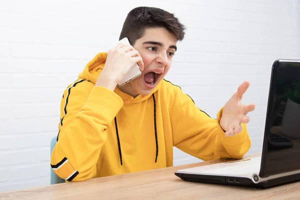 Jovem Com Telefone Celular Gritando Com Laptop — Fotografia de Stock