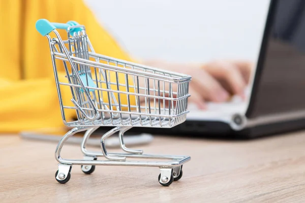 hands typing on the computer and shopping cart, online purchases