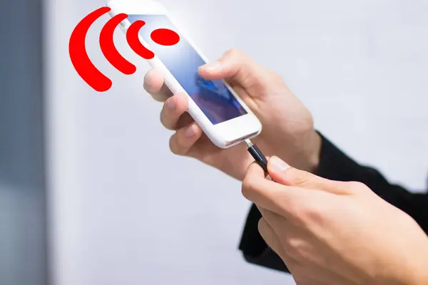 hand with mobile phone and wifi signal charging