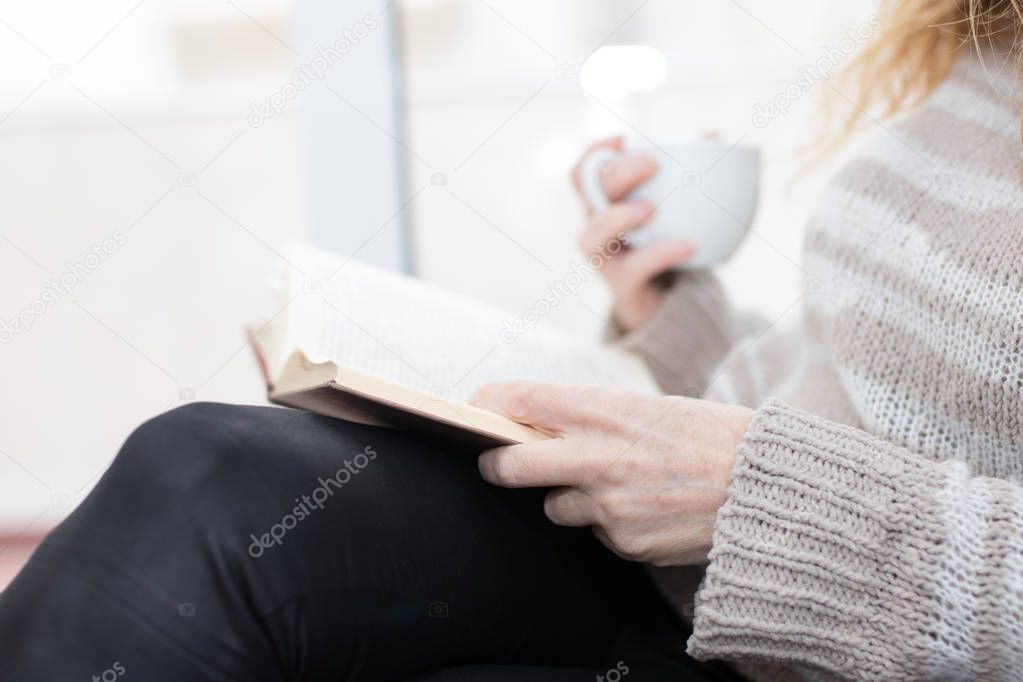 adult woman hands with book, reading