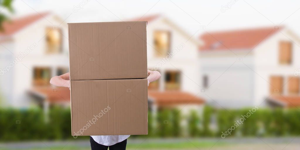 young man with boxes of removal or parcel with houses of background