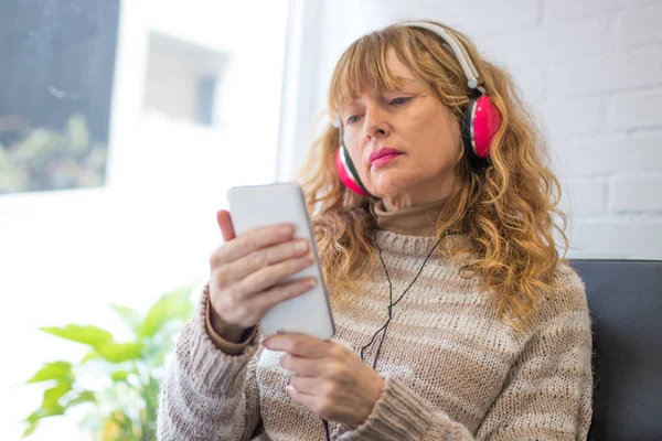 Vuxen Kvinna Soffan Med Hörlurar Och Telefon — Stockfoto