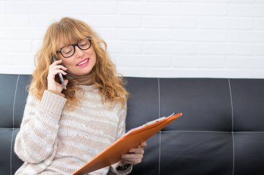 evde veya ofiste cep telefonu ve belgeleri ile yetişkin kadın