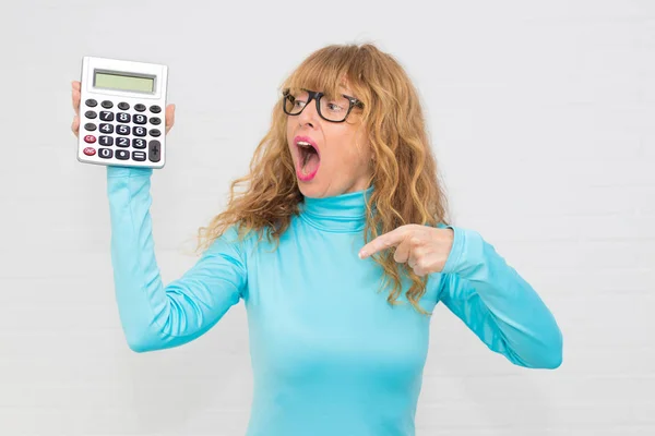 isolated adult woman with calculator and expression of surprise