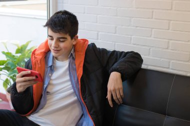 kanepede oturan cep telefonu ile genç