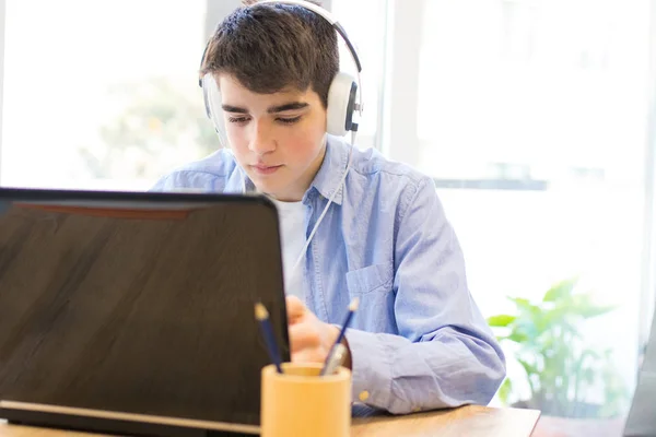 コンピュータのラップトップとヘッドフォンを持つ十代の学生 — ストック写真