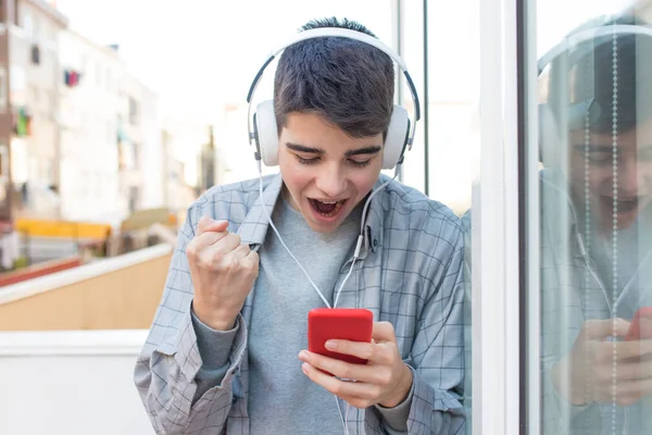 Jeune Euphorique Avec Téléphone Portable Écouteurs Célébrant Succès — Photo