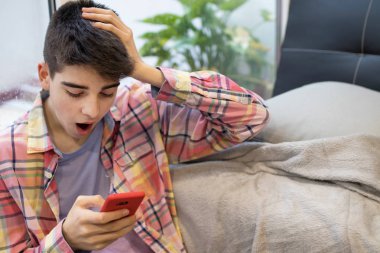 cep telefonu ve sürpriz ifade ile genç