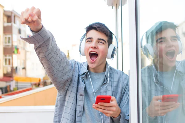 Jonge Euforische Met Mobiele Telefoon Hoofdtelefoon Vieren Succes — Stockfoto