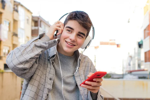 Jeune Étudiant Avec Téléphone Portable Écouteurs Extérieurs — Photo