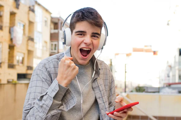 Young Euphoric Mobile Phone Headphones Celebrating Success — Stock Photo, Image