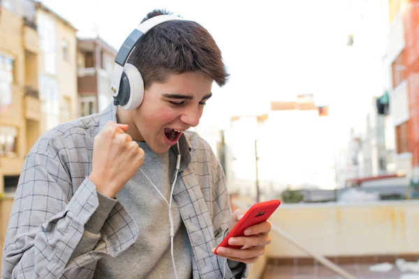Junge Euphoriker Mit Handy Und Kopfhörer Feiern Erfolg — Stockfoto