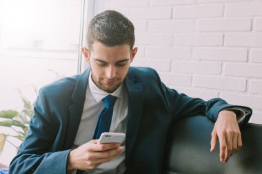 kanepede cep telefonu ile iş adamı