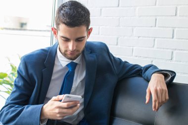 kanepede cep telefonu ile iş adamı