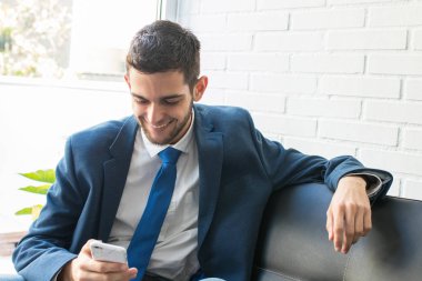 kanepede cep telefonu ile iş adamı