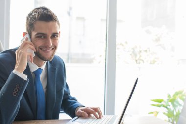 Bilgisayarlı ve cep telefonlu iş adamı