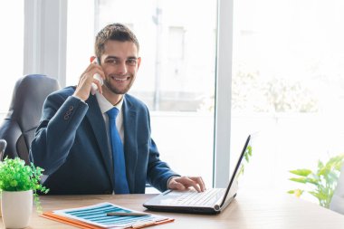 Bilgisayarlı ve cep telefonlu iş adamı