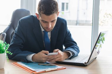 Bilgisayarlı ve cep telefonlu iş adamı