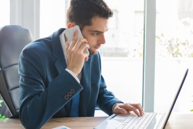 Bilgisayarlı ve cep telefonlu iş adamı