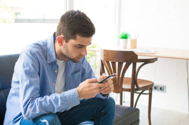 evde cep telefonu ile genç adam veya genç