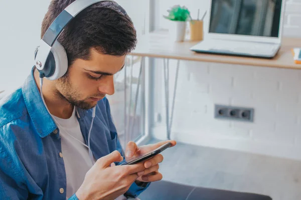 Hombre Casa Con Teléfono Móvil Auriculares —  Fotos de Stock