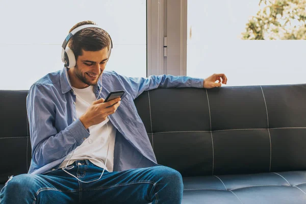 Jeune Homme Mode Avec Téléphone Portable Écouteurs Sur Canapé — Photo