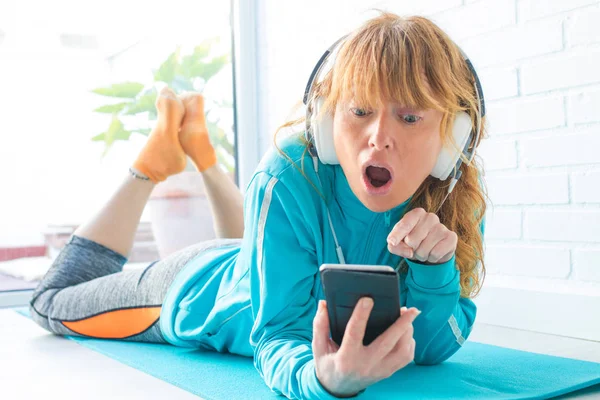 spor giyim kadın telefon ve kulaklık ile müzik dinlerken