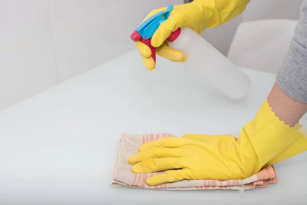 hands with gloves cleaning with spray