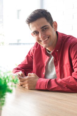 Masada ya da masada cep telefonu olan genç bir adam.