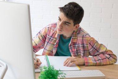 ev masası veya okulda bilgisayar ile genç öğrenci