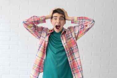 beyaz duvarda izole sürpriz bir ifade ile genç genç veya öğrenci