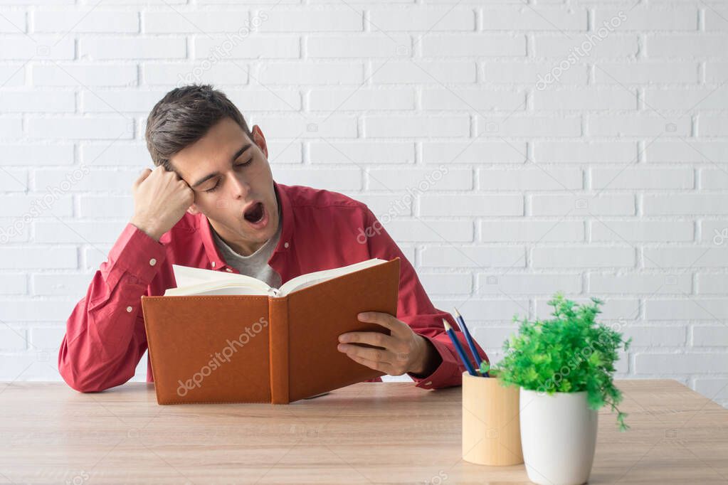 young man or student with the book on the table