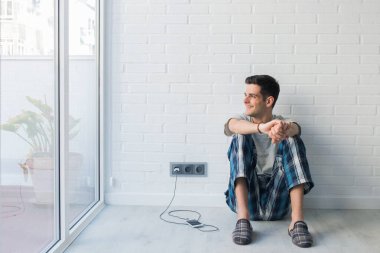 Sabahları evde ya da odada pijamalı genç bir adam.