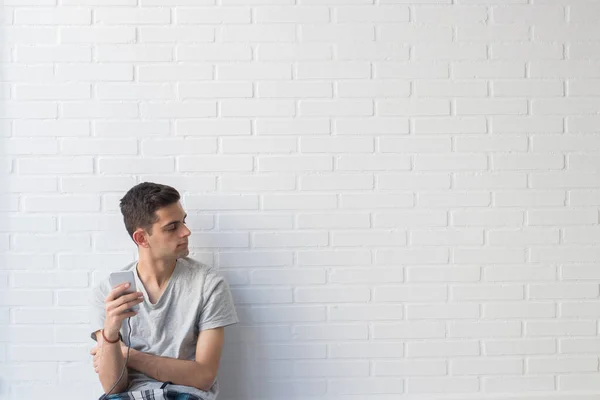 Jovem Com Telefone Celular Fundo Tijolo Branco — Fotografia de Stock