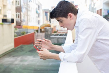 cep telefonu ve sürpriz ifade ile genç