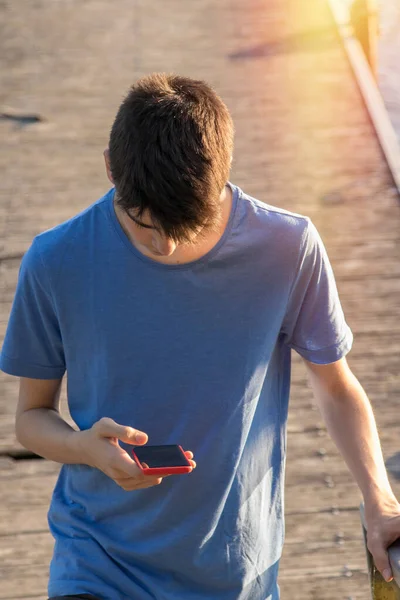 日落时分拿着手机的年轻人 — 图库照片
