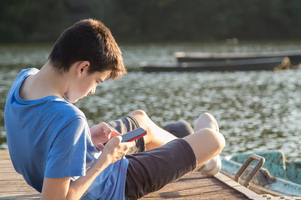 Ung Man Med Mobiltelefon Bryggan Vid Solnedgången — Stockfoto