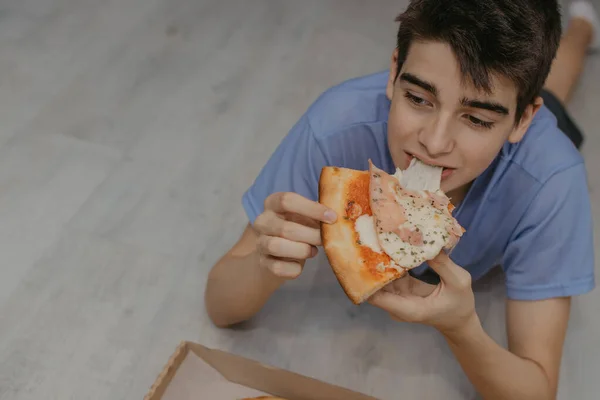 Νεαρός Άνδρας Τρώει Πίτσα Στο Σπίτι Fast Food — Φωτογραφία Αρχείου