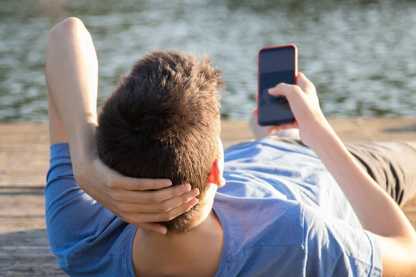 Jonge Man Met Mobiele Telefoon Bij Zonsondergang Buiten — Stockfoto