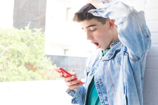 Zaskoczony Lub Przerażony Młody Człowiek Oglądający Telefon Komórkowy — Zdjęcie stockowe