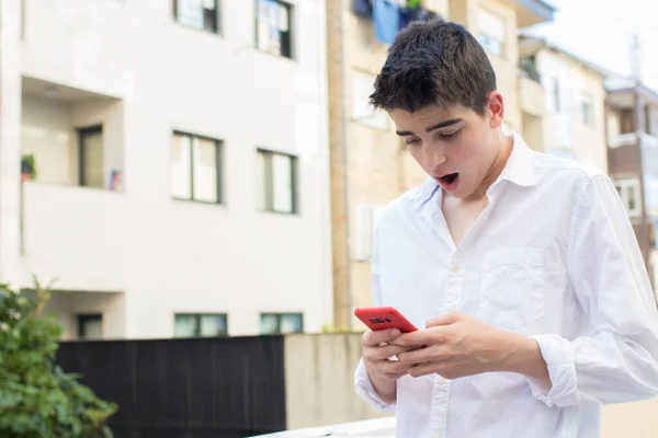 Młody Człowiek Zewnątrz Zaskoczony Patrząc Telefon Komórkowy — Zdjęcie stockowe