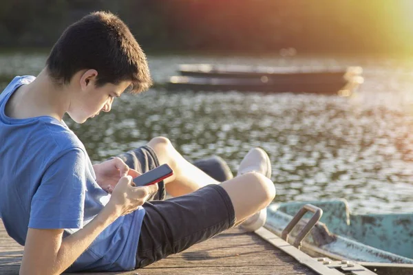 Jonge Man Met Mobiele Telefoon Steiger Bij Zonsondergang — Stockfoto