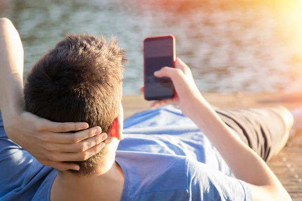 Młody Człowiek Telefonem Komórkowym Zachodzie Słońca Zewnątrz — Zdjęcie stockowe