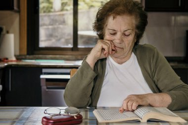 Düşünceli bir yüzü olan yaşlı bir kadının portresi.