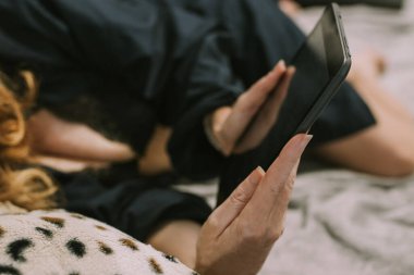 Sınıfta tabletli ya da bilgisayarlı bir kadın var.