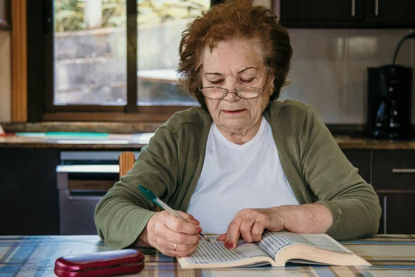 Egy Idősebb Portréja Olvasás Közben Vagy Keresztrejtvénnyel Otthon — Stock Fotó
