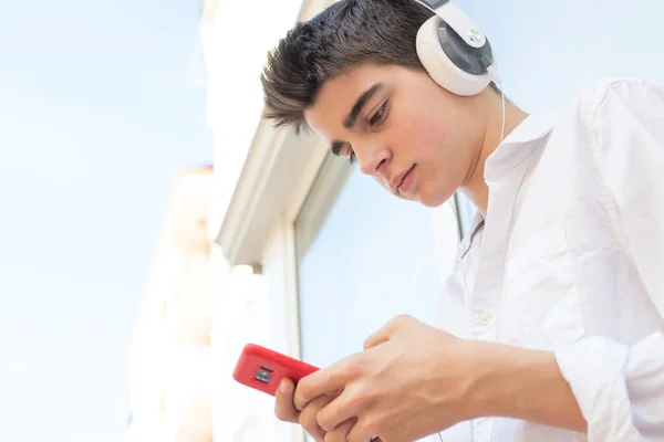 Ung Man Med Telefon Och Hörlurar Lyssnar Musik Utomhus Staden — Stockfoto