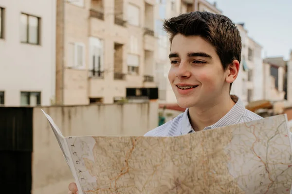 young man with city map on the street outdoors