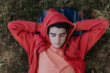 Genç ya da genç bir öğrenci sahada yatıyor.