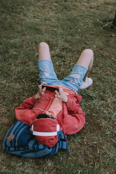 Junger Mann Liegt Mit Handy Und Kopfhörer Feld — Stockfoto